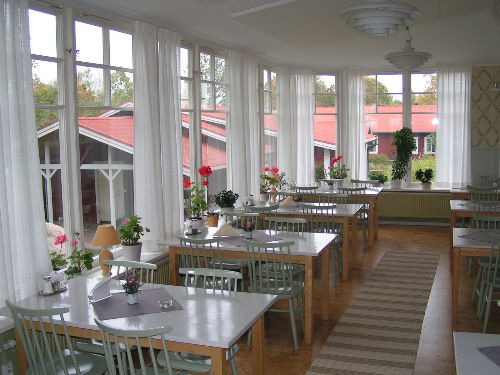 Ett rum med stora fönster, stol och bordar där konferens hålls nära Uppsala & Stockholm