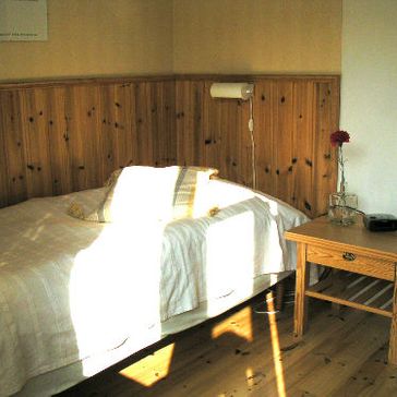 Sovrum med Säng och Nattduksbord på Syninge Kursgård